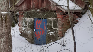 Rähjäinen talo, jonka ovessa lukee "Mielisairaala"